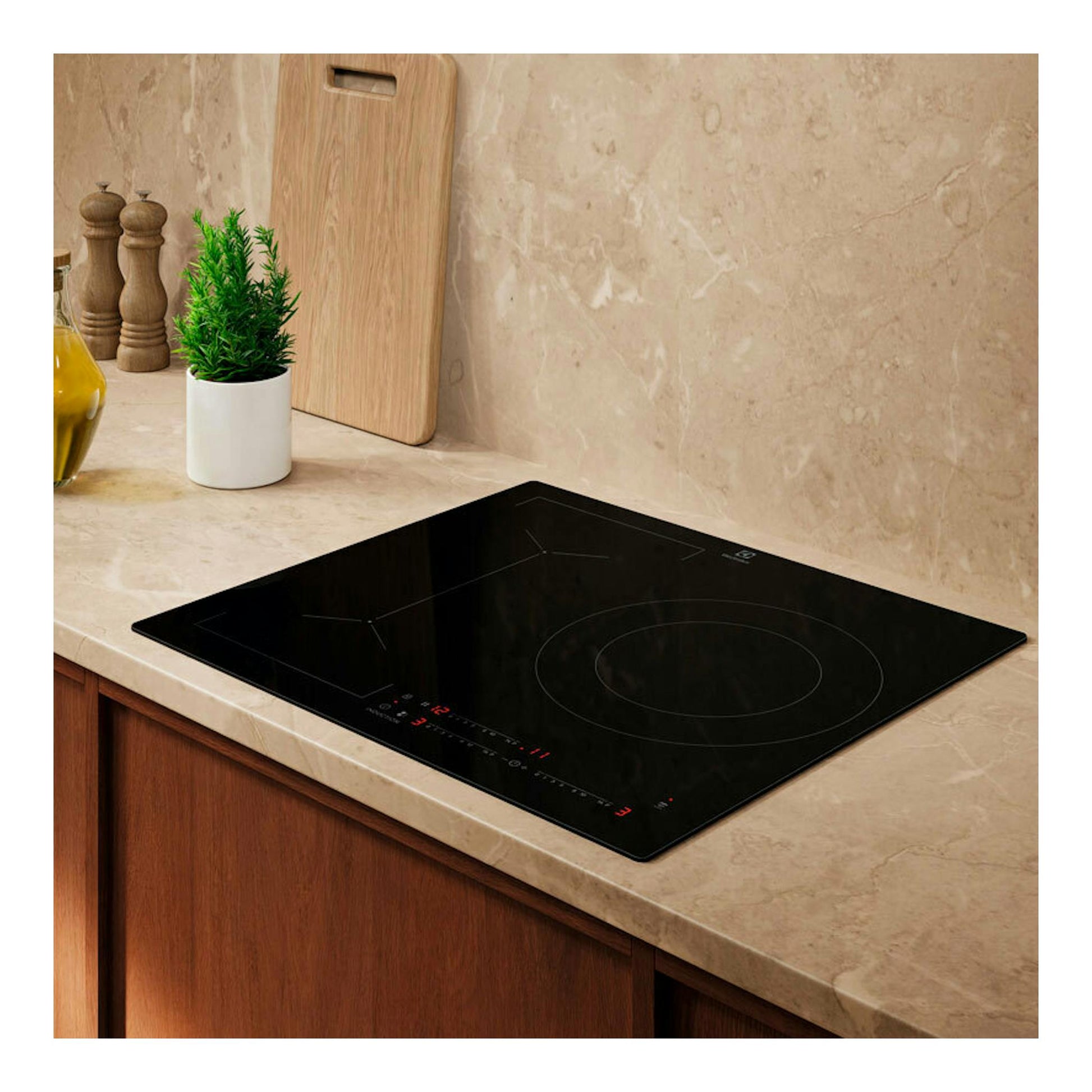 Placa de inducción Electrolux LIV63340CK negra de 60 cm, vista en ángulo sobre encimera beige.