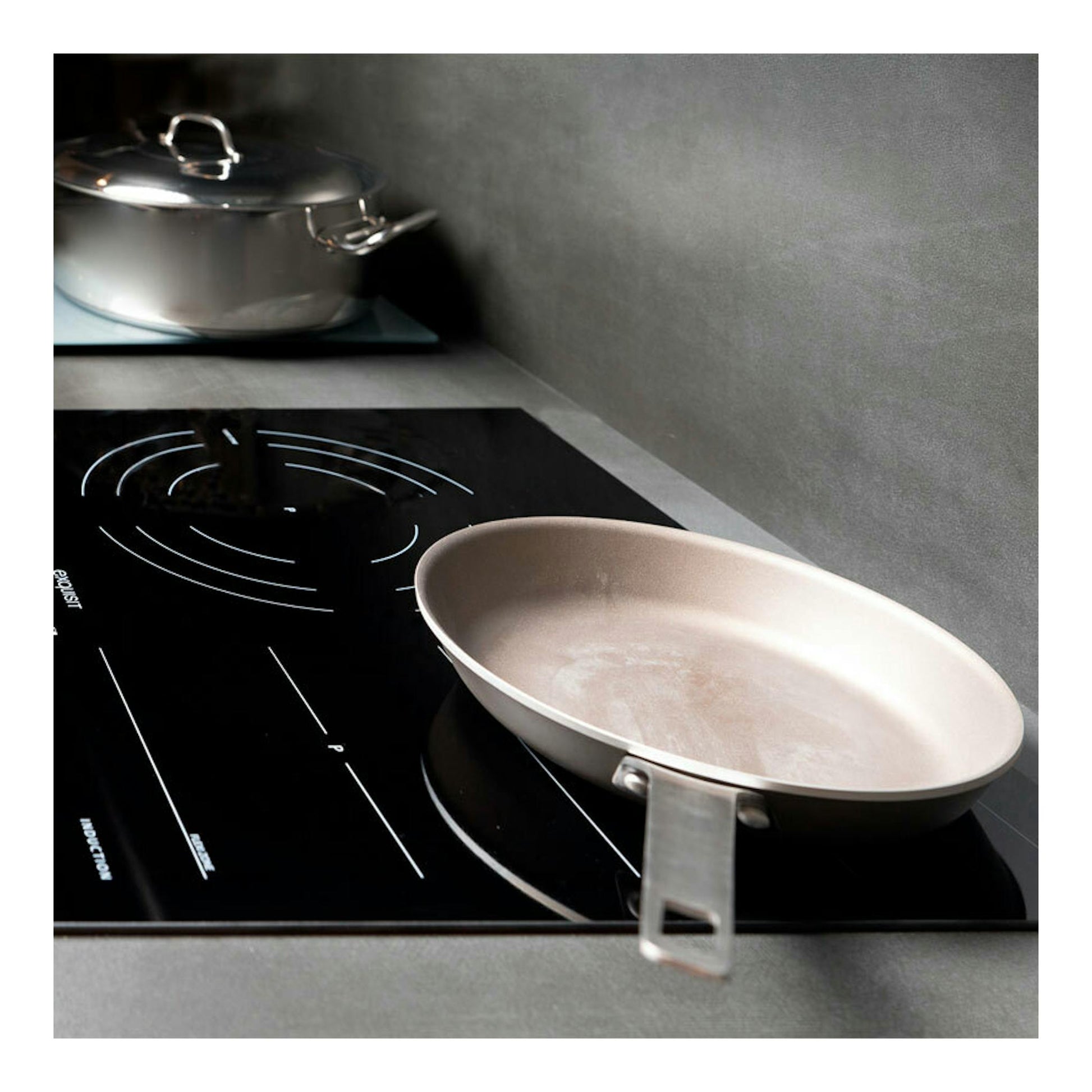 Placa de inducción negra Exquisit EKI 653F, vista en ángulo, con una sartén y una olla encima.