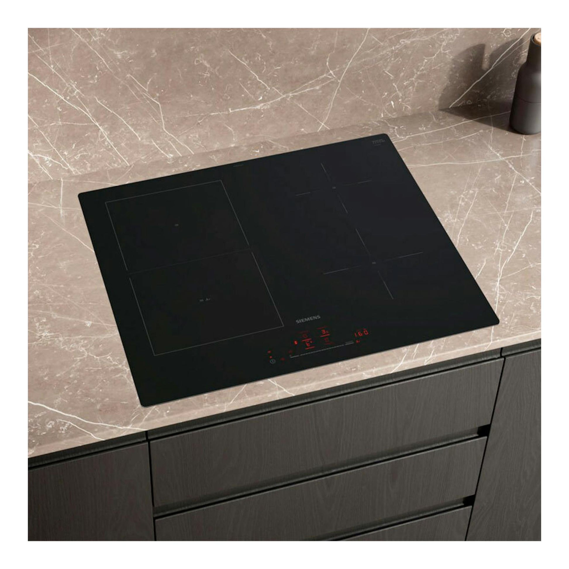 Placa de inducción Siemens ED61AHSC1E negra, vista en ángulo sobre encimera de mármol.