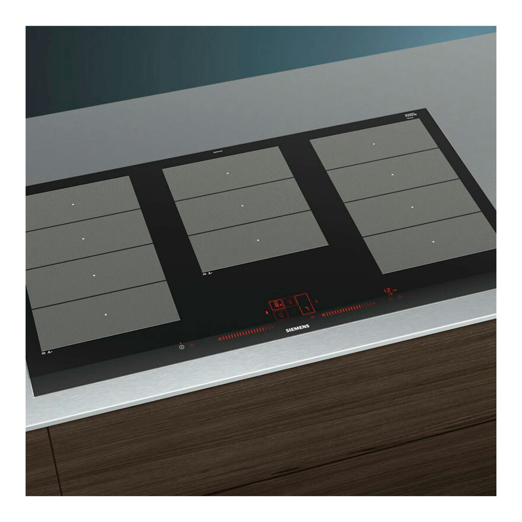 Placa de inducción Siemens EX975LXC1E, vista superior inclinada, cristal negro con zonas grises y controles rojos.