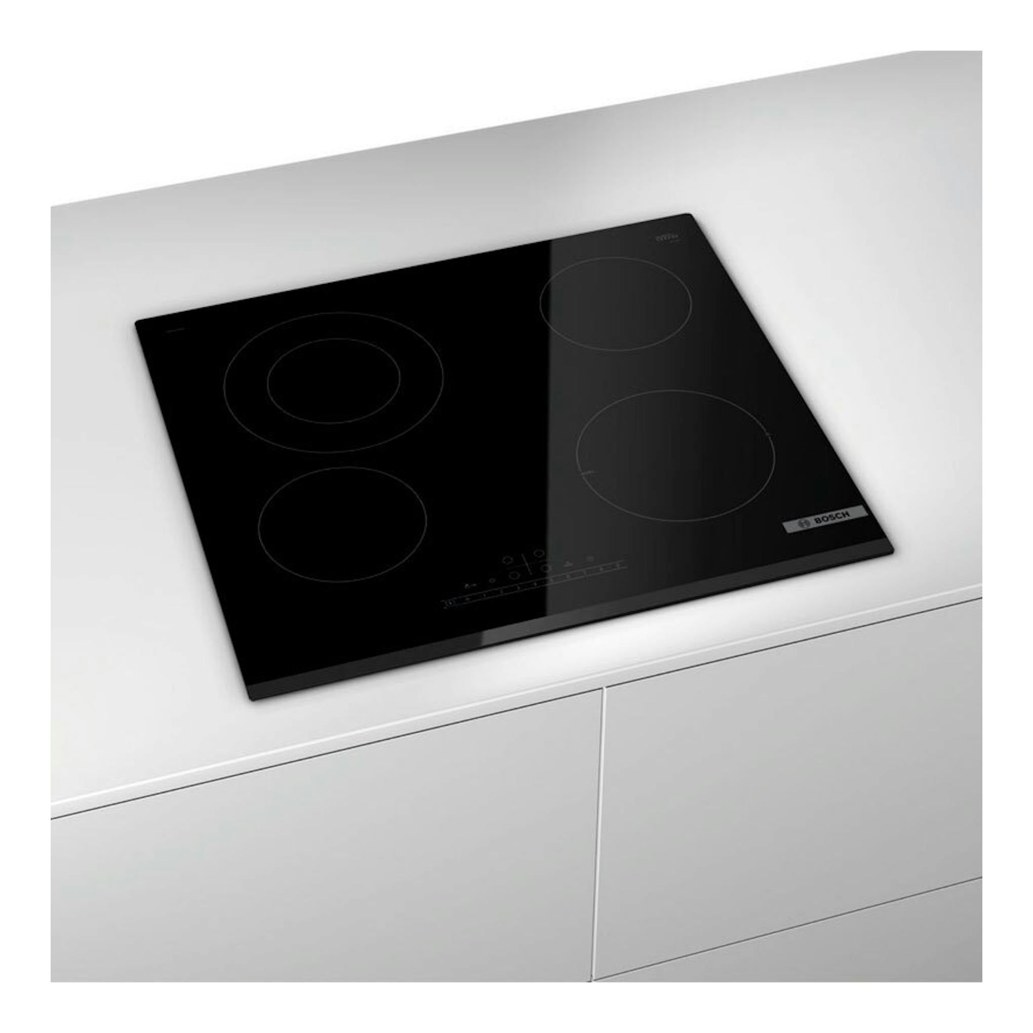 Placa vitrocerámica Bosch PKF631FP3E negra, vista en ángulo superior sobre encimera blanca.
