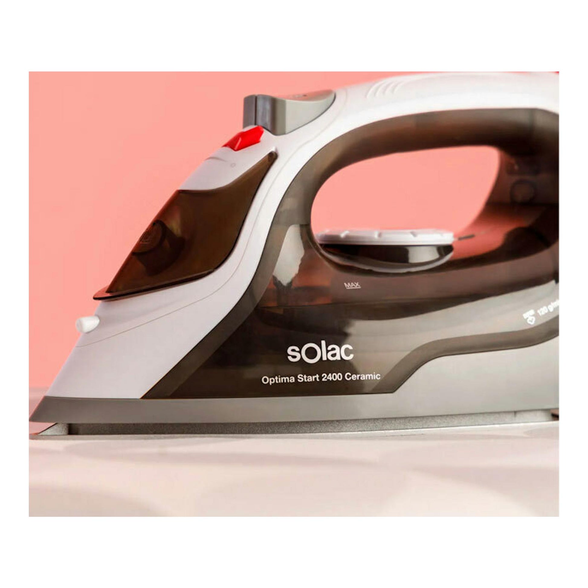 Plancha de vapor Solac Optima Start 2400 Ceramic, vista lateral, blanca y negra, sobre fondo rosa.