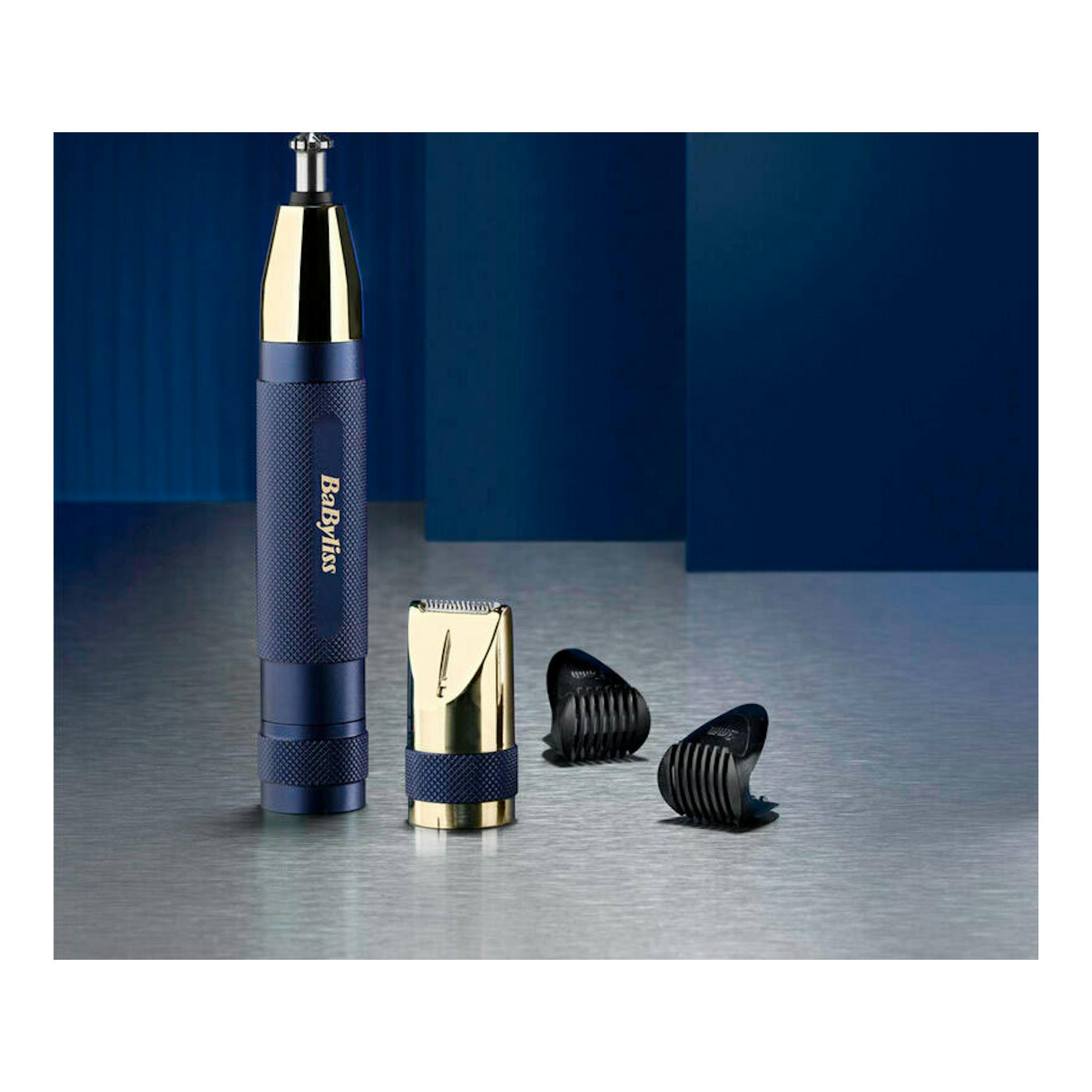 Recortador nasal Babyliss E112E azul y dorado, visto de frente, con accesorios sobre fondo gris.