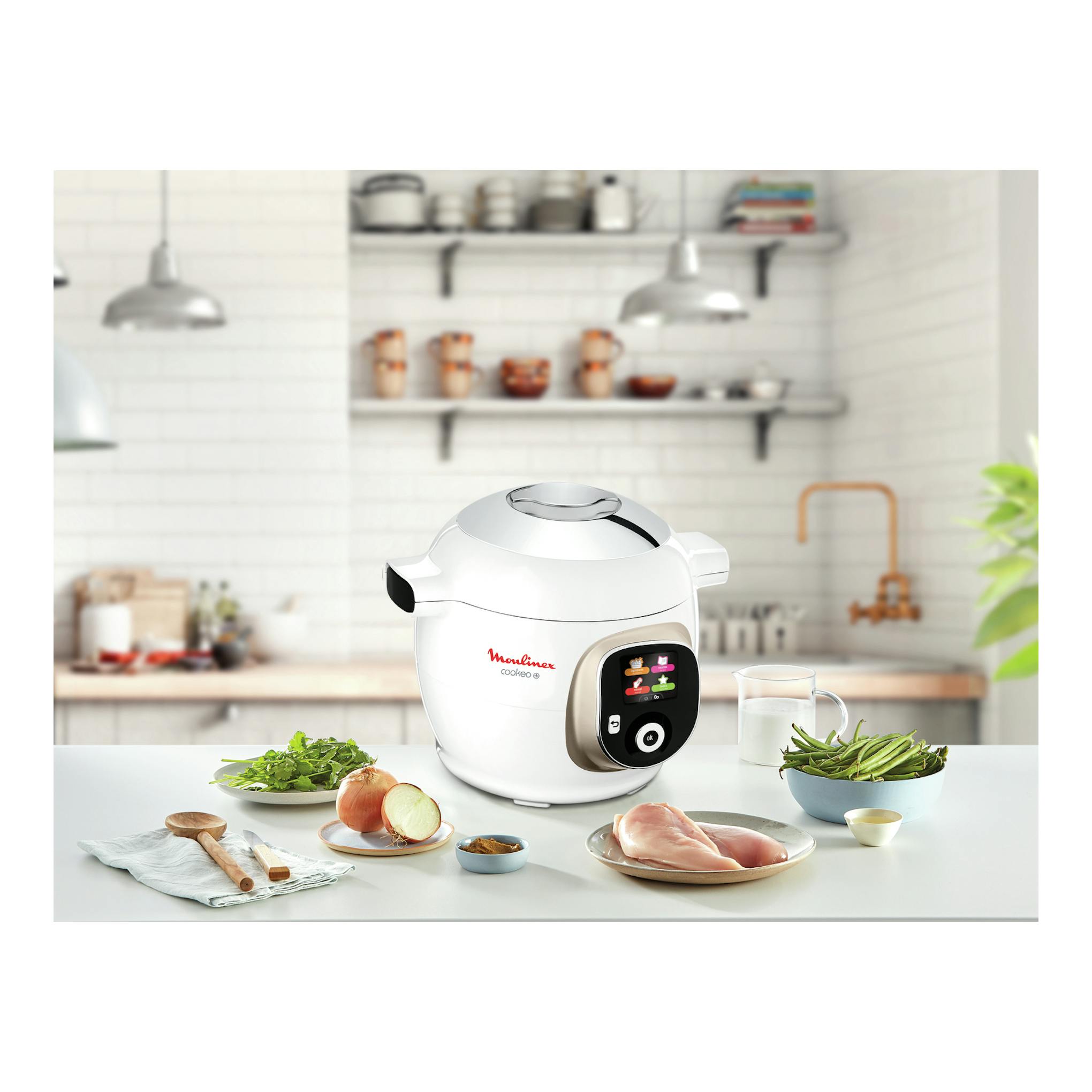 Robot de cocina Moulinex Cookeo+ blanco, vista frontal, con pantalla LCD y alimentos sobre la encimera.