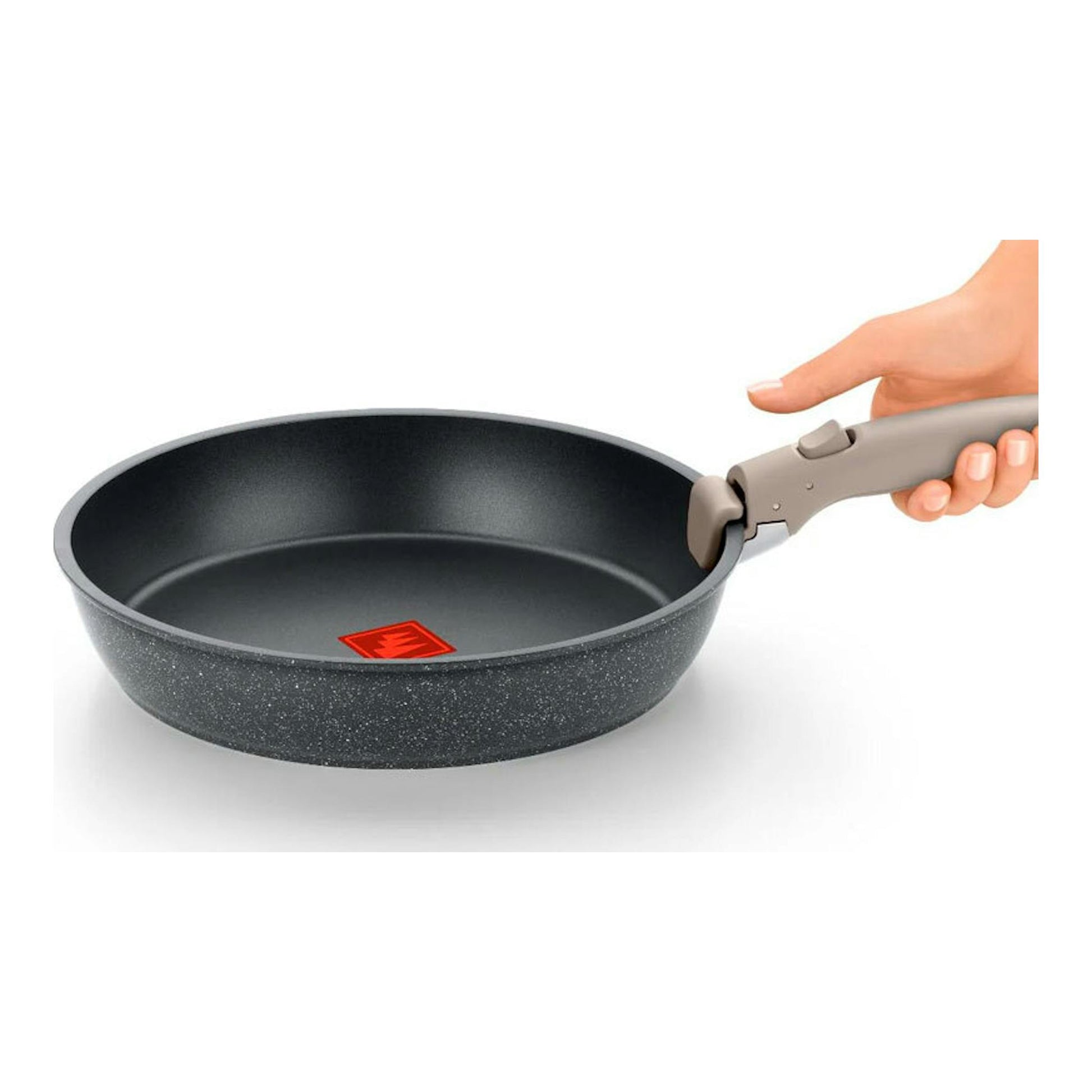 Sartén Monix Pietra gris moteada con mango desmontable, vista lateral, sostenida por una mano.