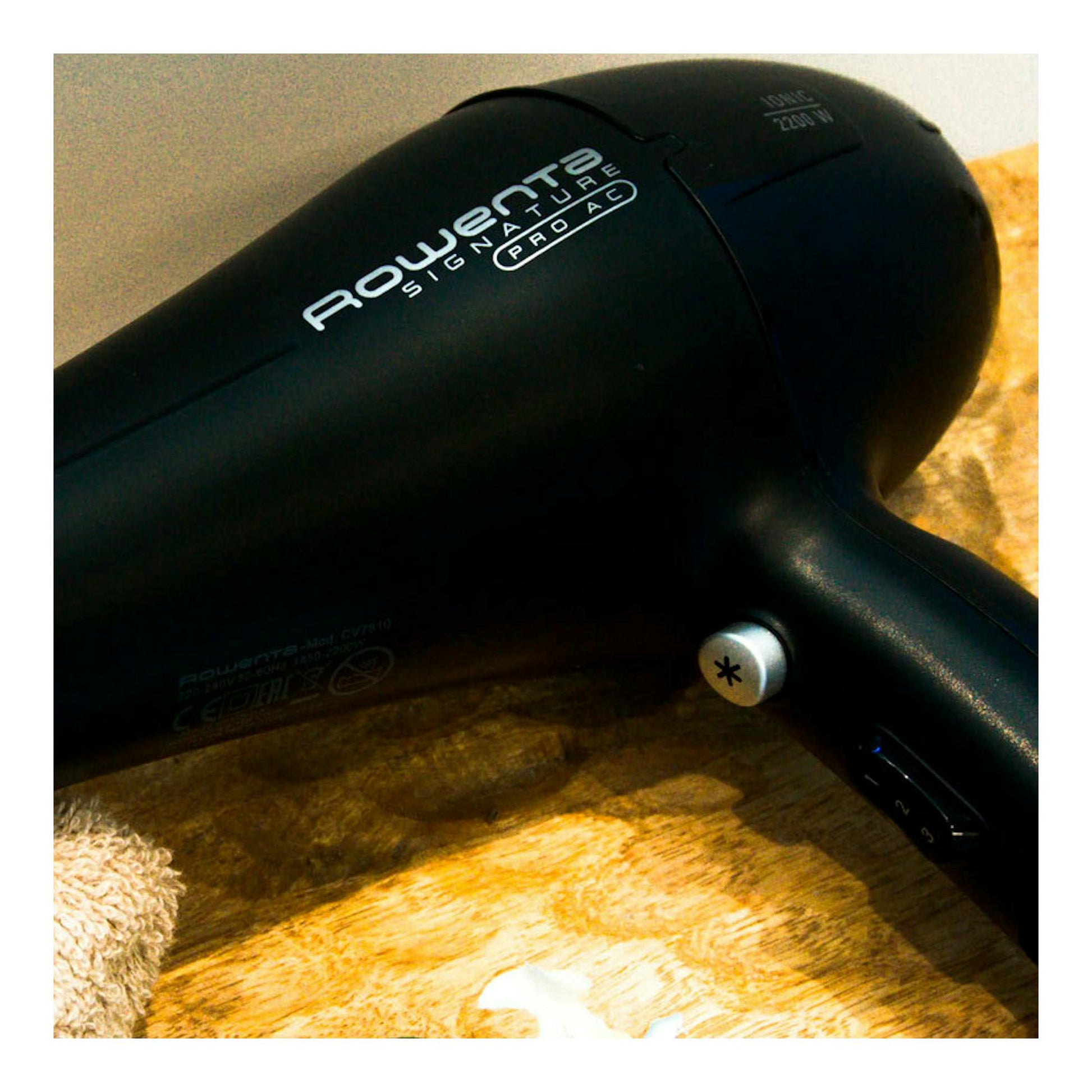 Secador Rowenta CV7810F0 negro, vista lateral en ángulo sobre una superficie de madera.
