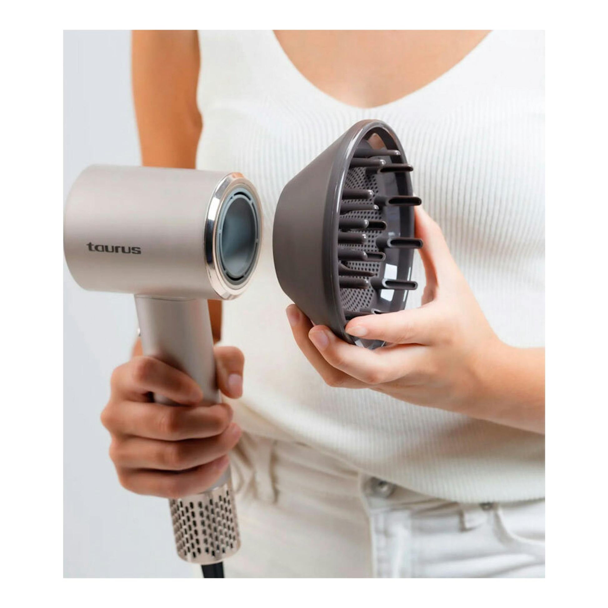 Secador Taurus Digital Force Protect beige, con difusor negro desmontable, sostenido por una persona.