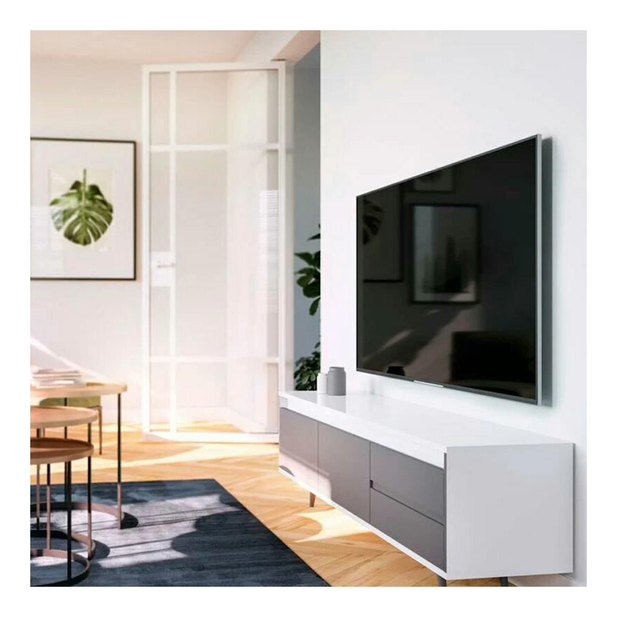 Vista lateral de televisor negro montado en pared con soporte Vogels TVM 3603, en salón moderno.