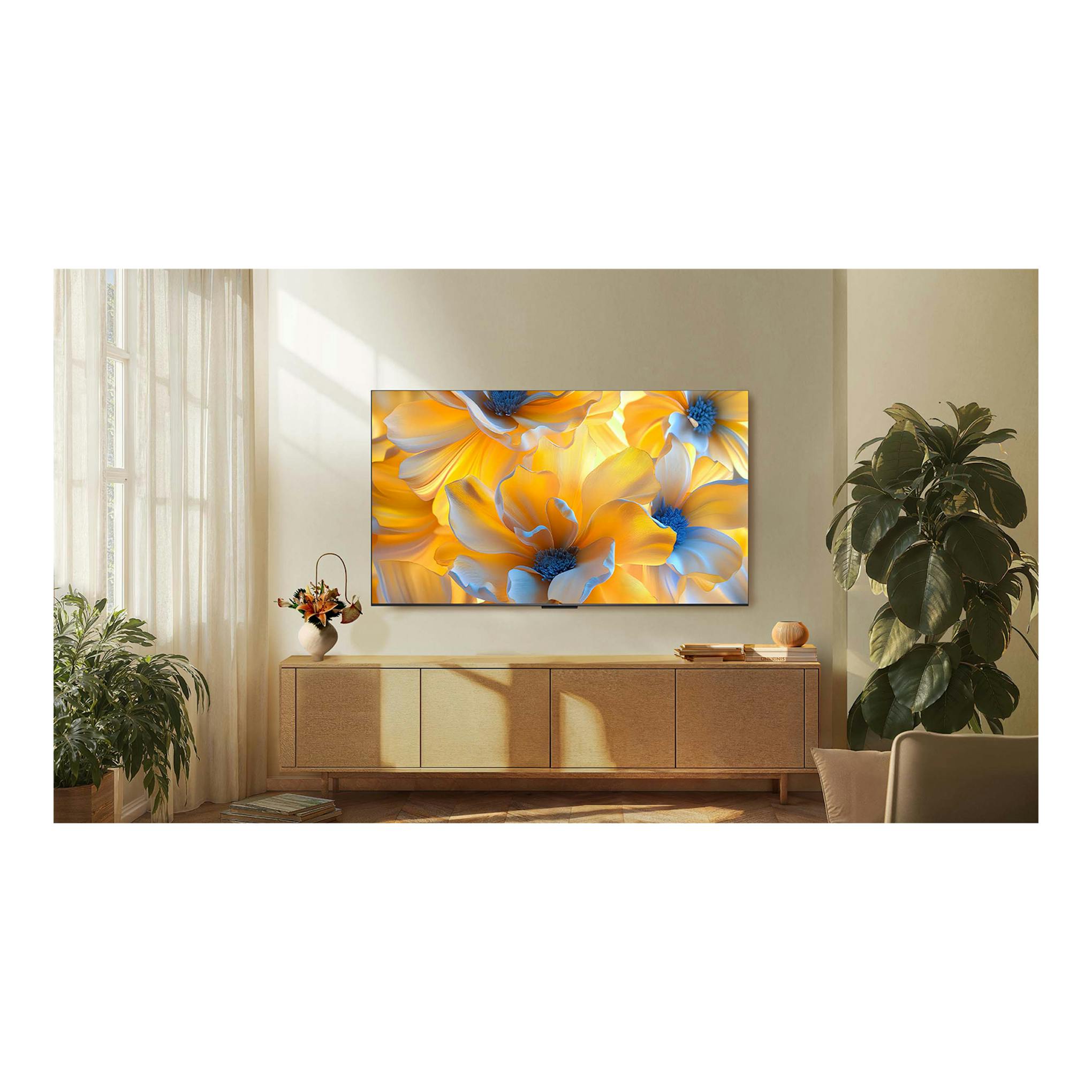 Televisor TCL C6K 55C6K montado en pared, vista frontal, con pantalla mostrando flores amarillas.