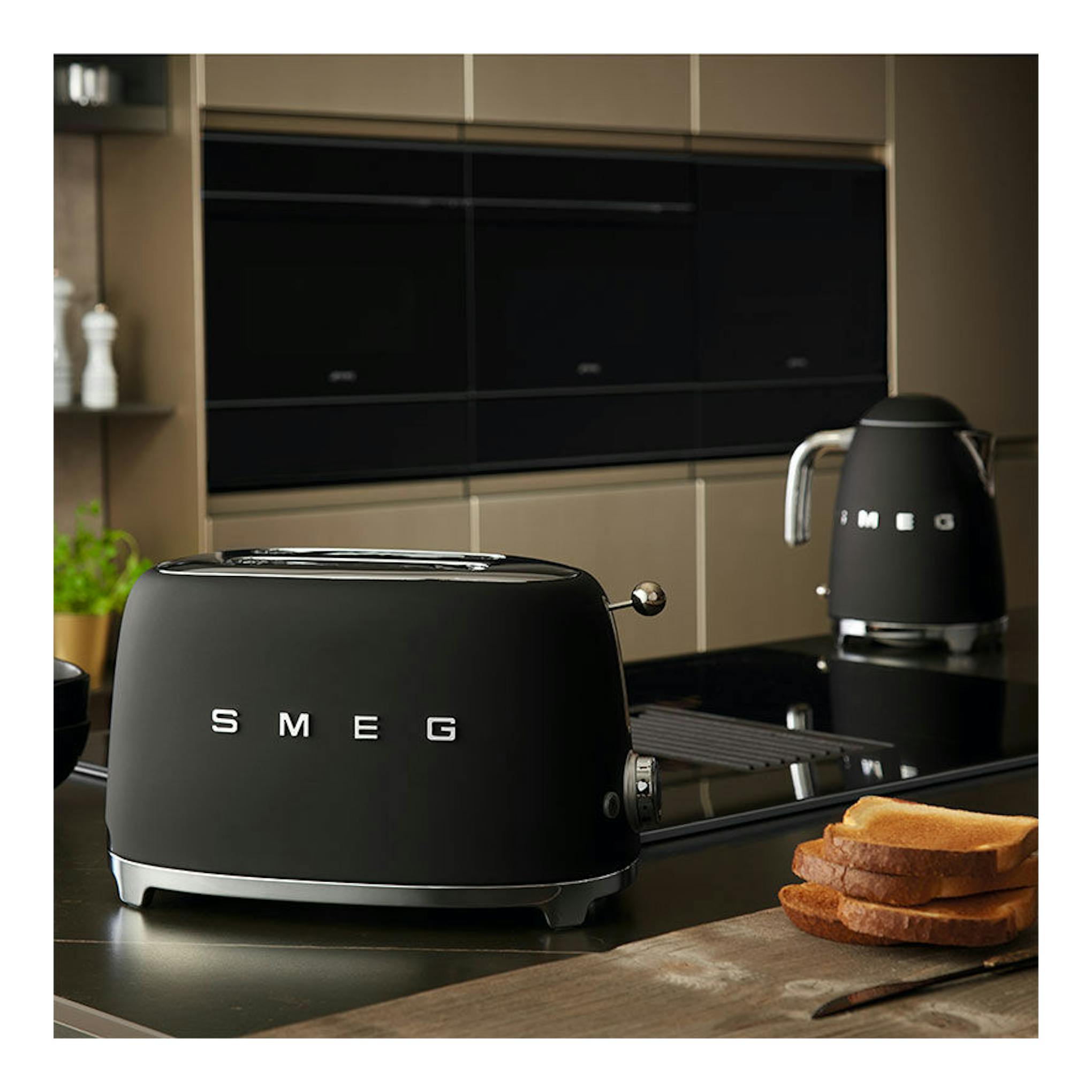 Tostador Smeg TSF01BLMEU negro mate, vista frontal-izquierda en encimera de cocina.