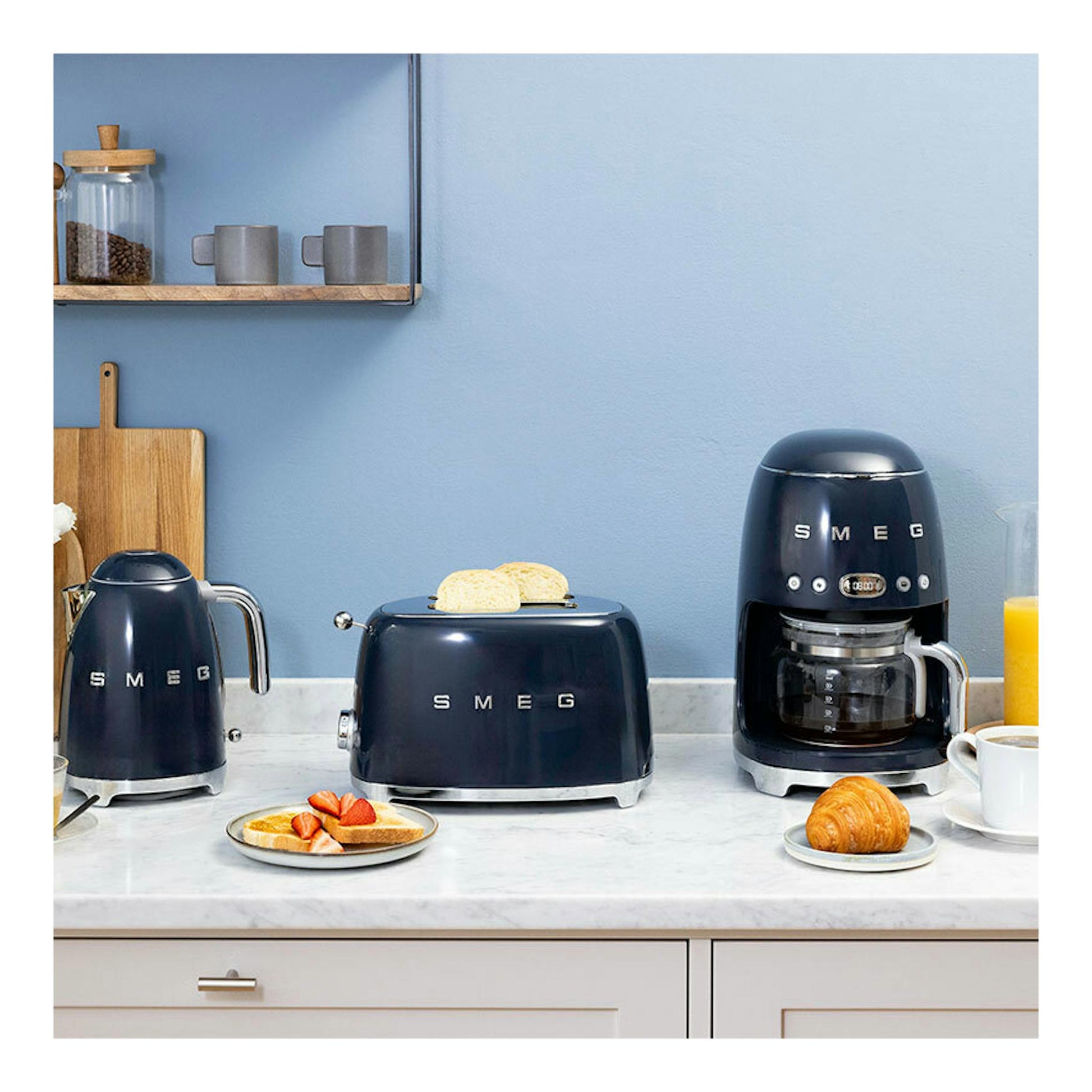 Tostador Smeg TSF01NBEU azul marino, vista frontal sobre encimera, con dos rebanadas de pan tostándose.
