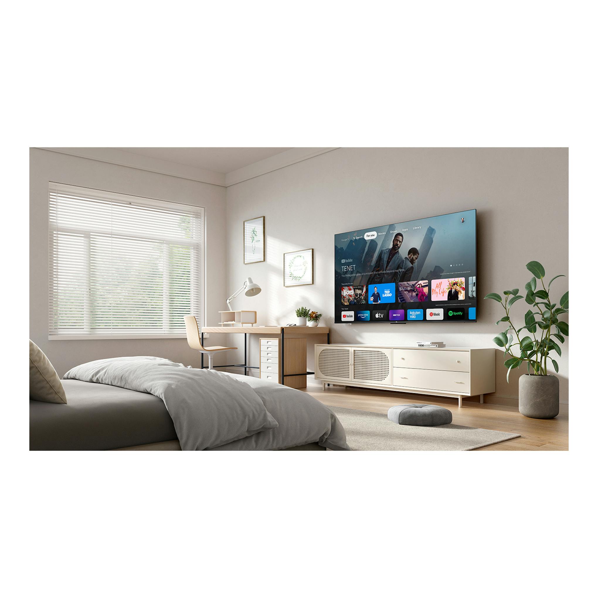 TV TCL 75P6K 4K montada en la pared en un dormitorio, vista frontal, con interfaz Google TV.
