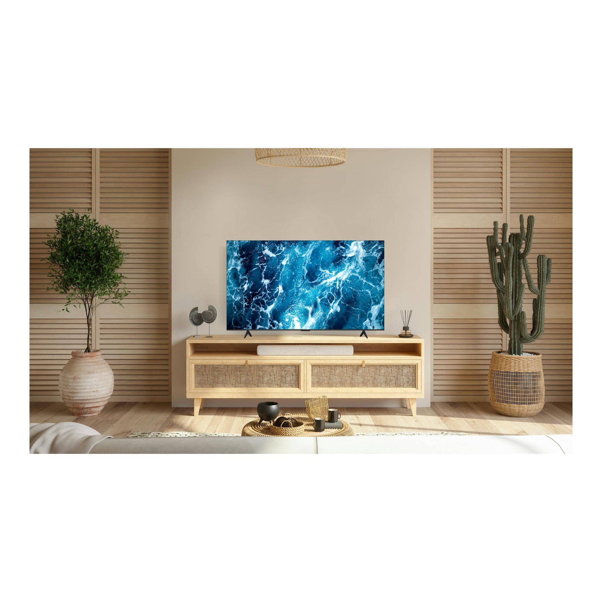 Televisor TCL 85T69C, vista frontal, pantalla con imagen azul de agua, sobre mueble de madera en salón.