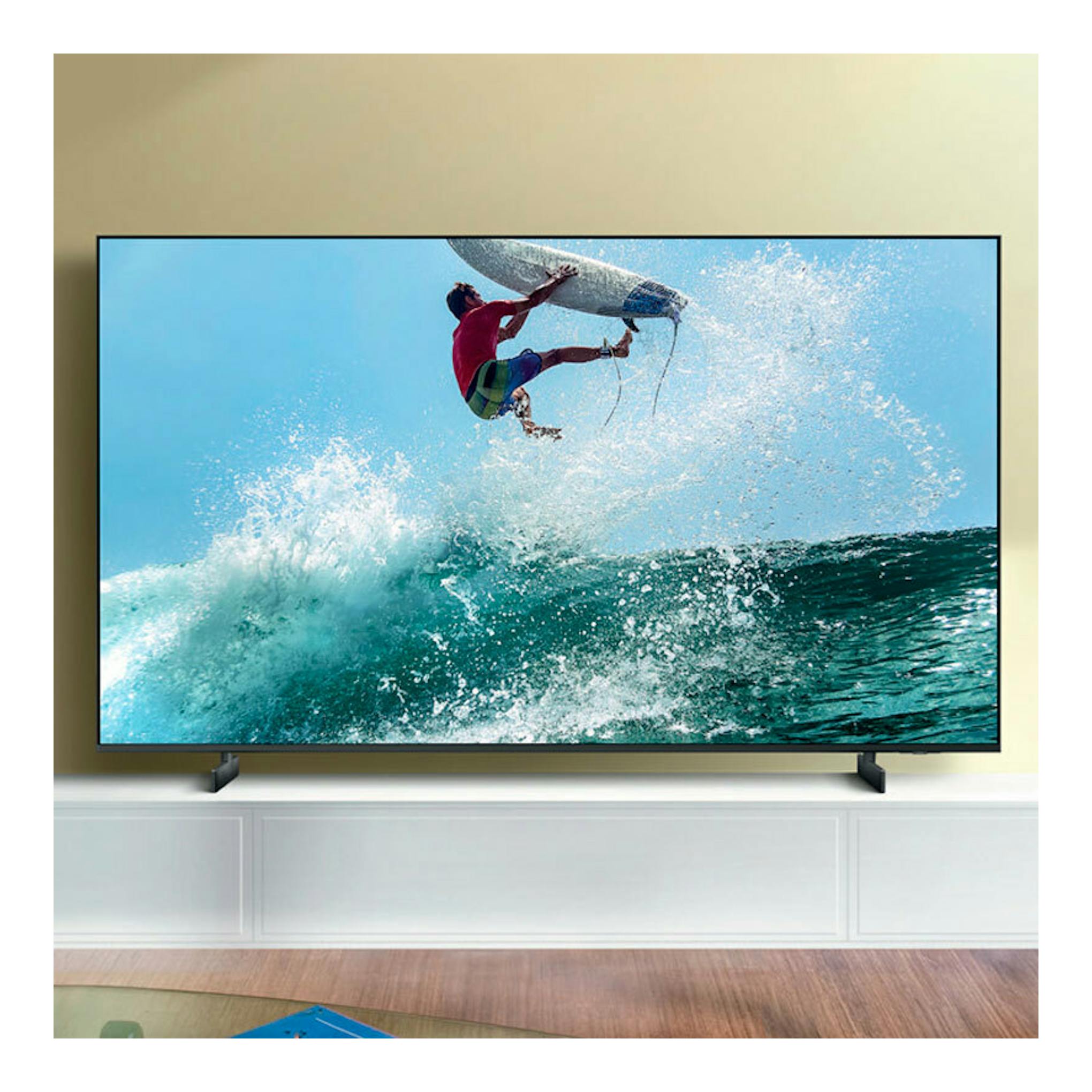TV Samsung TU65DU7105KXXC de frente, con marco negro, mostrando una escena de surf sobre fondo azul.