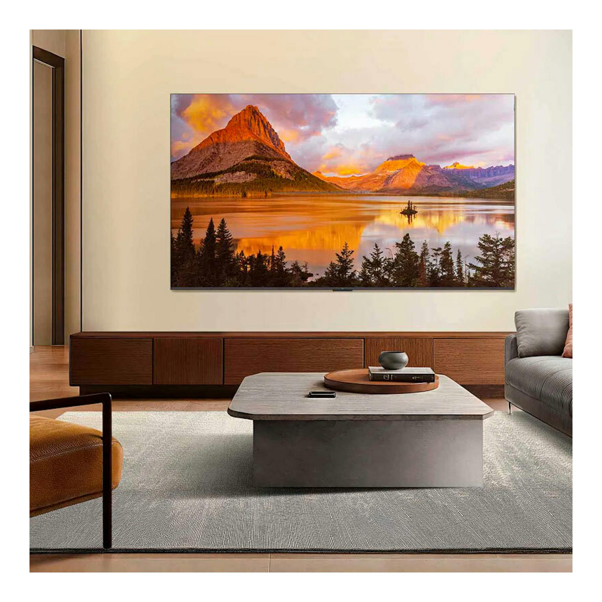 TV TCL 50P7K QLED 4K de 50" montado en la pared, con paisaje de montañas al atardecer en una sala moderna.