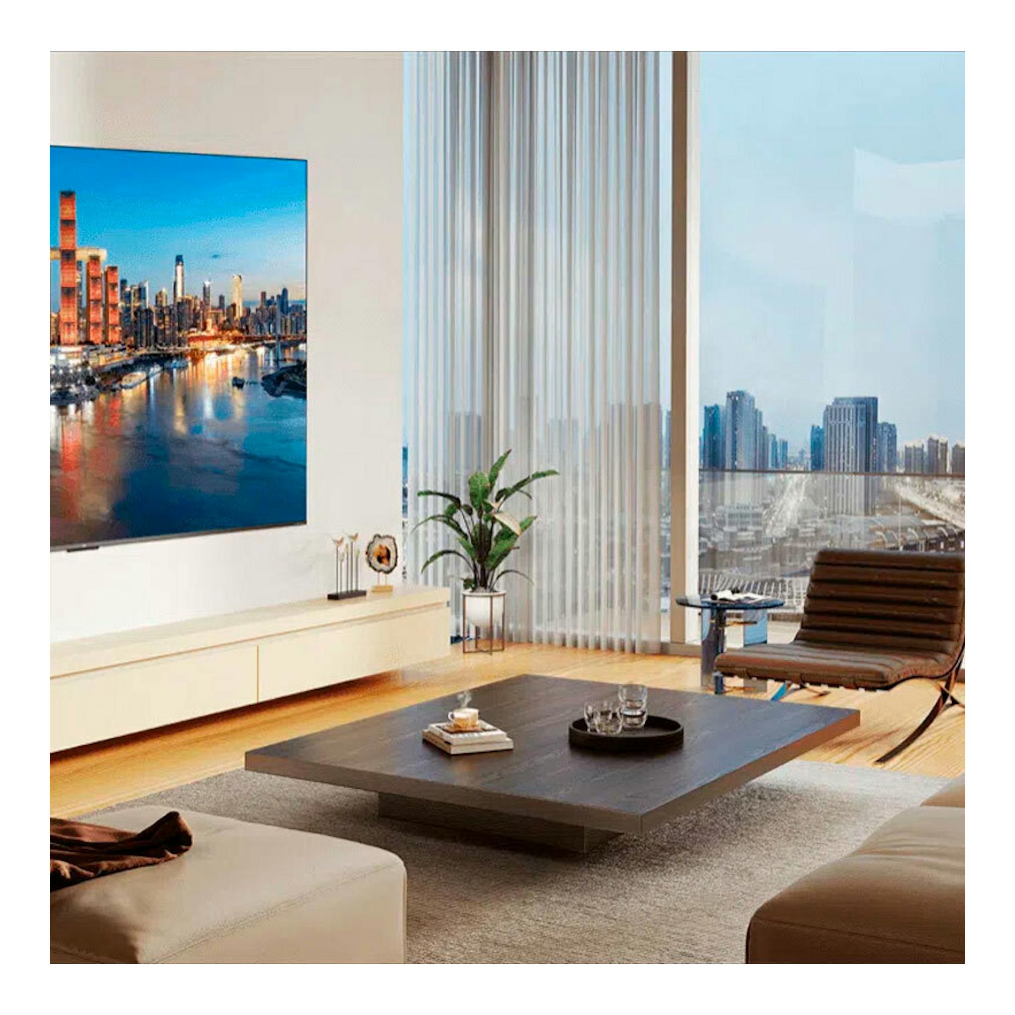 TV TCL 65C7K MiniLED 4K de 65 pulgadas, vista frontal en pared, en salón moderno con ciudad en pantalla.