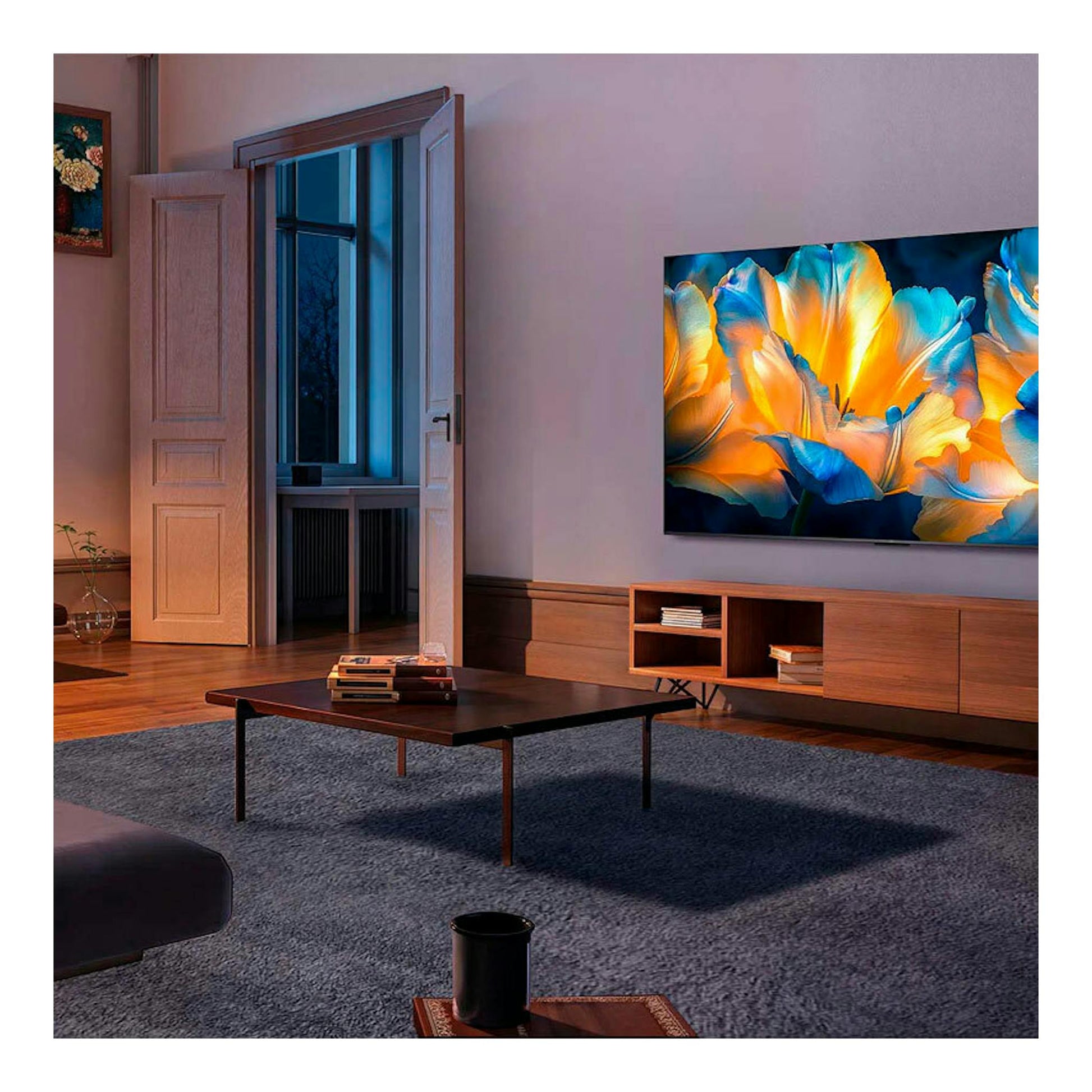 TV TCL 98C6K MiniLED 4K de 98", montado en pared, con imagen de flores azul y naranja.